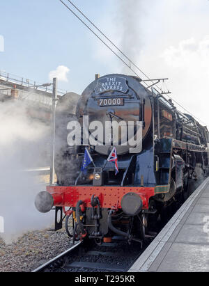York, UK. 30th March 2019. A steam locomotive “The Brexit Express” at the platform on York Station. Steam is emitted from the engine and flags adorn the front. Credit: Jack Cousin/Alamy Live News Stock Photo