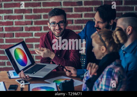 team of designers in the workplace in front of an open laptop di Stock Photo