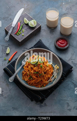 Spicy asian mee goreng mamak with eggs, ketchup and chili, top view. Stock Photo