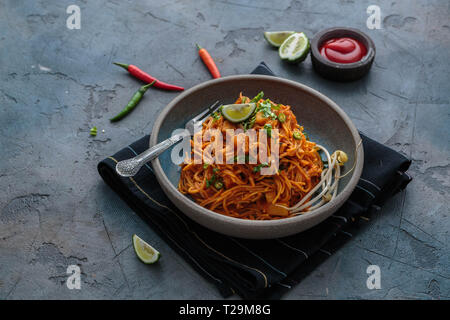 Indian mee goreng, spicy fried noodles in a plate, Singaporean and Malaysian cuisine copy space. Stock Photo