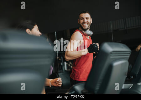 Young couple running on treadmills in modern gym Stock Photo