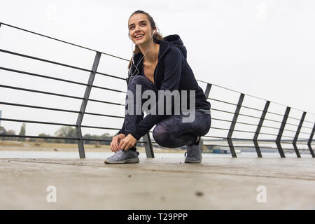 Close up of young woman tying shoe laces outdoor Stock Photo