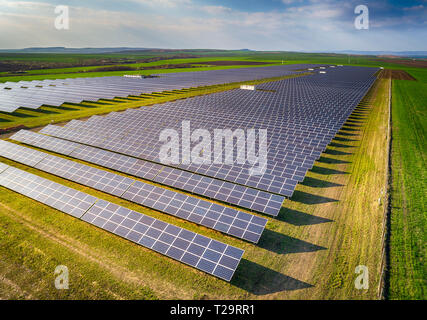 Solar panel produces green, environmentaly friendly energy from the setting sun. Aerial view from drone. Landscape picture of a solar plant Stock Photo