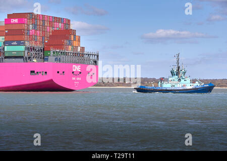 Tug PHENIX Guides The New, Ocean Network Express Container Ship, ONE GRUS, With The Distinctive Magenta Hull, As She Approaches Southampton Docks. UK Stock Photo