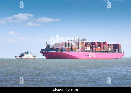 Ocean Network Express ULCS Container Ship, ONE GRUS, Passing A Red Funnel Ferry As It Approaches The Port Of Southampton, UK. 25 March 2019. Stock Photo