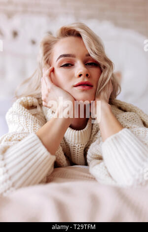 Young beautiful woman with natural makeup lying in bed Stock Photo