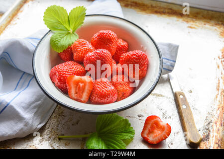 Ripe summer red strawberry in bowl at windowsill Stock Photo