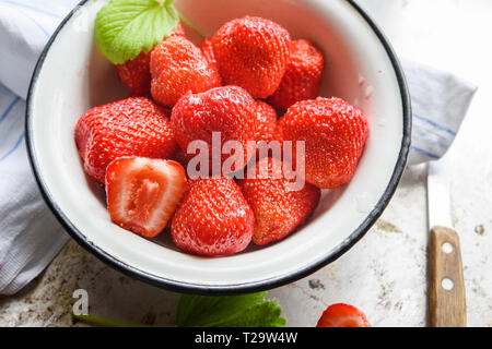Ripe summer red strawberry in bowl at windowsill Stock Photo