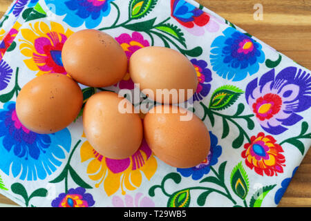 Eggs from organic farming from the village arranged on a colorful tablecloth in folk patterns Stock Photo