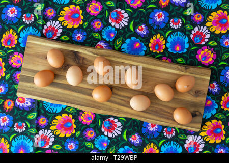 Eggs from organic farming from the village arranged on a colorful tablecloth in folk patterns Stock Photo