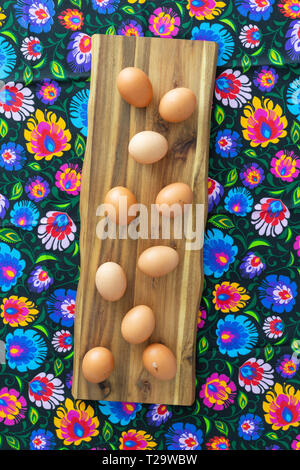 Eggs from organic farming from the village arranged on a colorful tablecloth in folk patterns Stock Photo