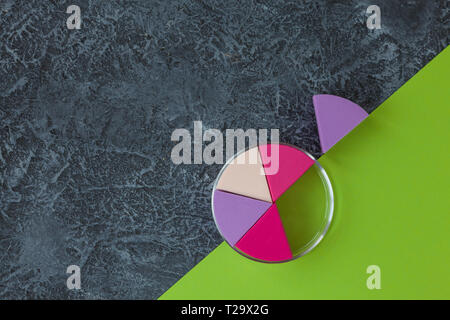 Make up sponges on dark stone background. Cosmetic applicator, green paper with copy space Stock Photo