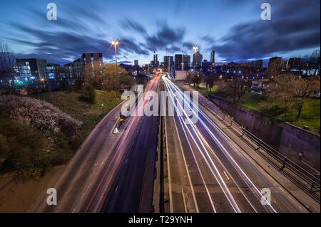 Leeds City skyline with light trails leading to it. Stock Photo