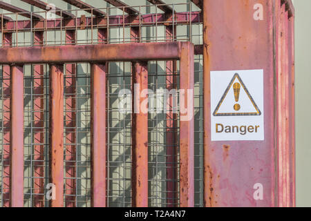 Fadding Sign Fading DANGER warning sign in an industrial area. Factory warning signs ...