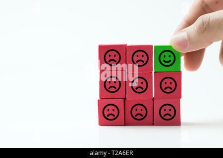 Unique, optimistic, happiness, difference concept using single happy face among many sad faces. Stock Photo