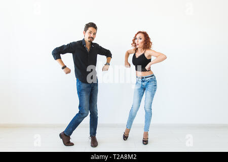 Social dance concept - Crazy dancing, cheerful couple over white background. Stock Photo