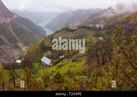 Lake Koman, Shkodër County, Albania : High angle view of farms and cottages perching on the slopes of the gorge over the Koman lake reservoir on the D Stock Photo