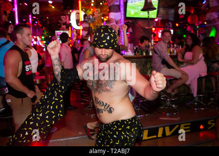 PATONG - An Australian tourist does a spontaneous strip act in front of a gogo bar on Bangla Road. The street is famous for it's nightlife. Stock Photo