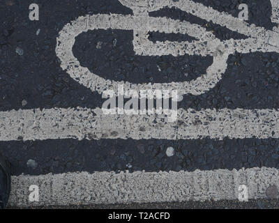 Close-up of a white sign and road markings of a cycle path on the black tarmac on a street in London, England, UK. Stock Photo