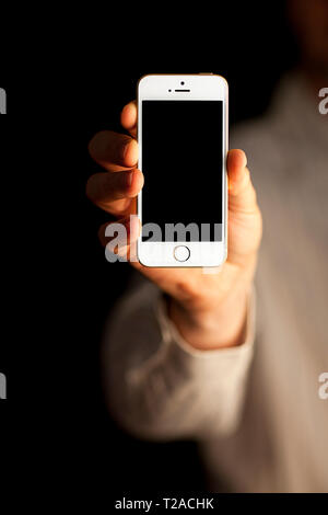 Hand holding up an iPhone Stock Photo