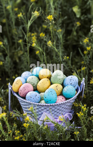 Closeup of spring Easter eggs collected in a purple bucket, traditional decoration - Image Stock Photo