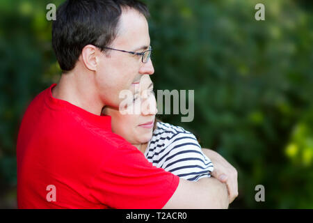Man in red shirt hugging wife Stock Photo