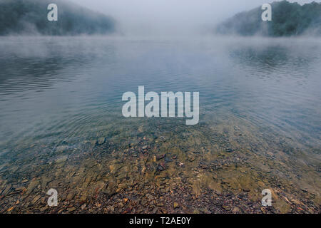 Ripples On Clear Mountain Lake With Misty Fog Stock Photo