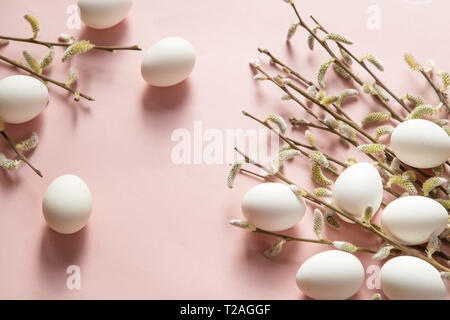 White eggs and willow branches on pink background Stock Photo