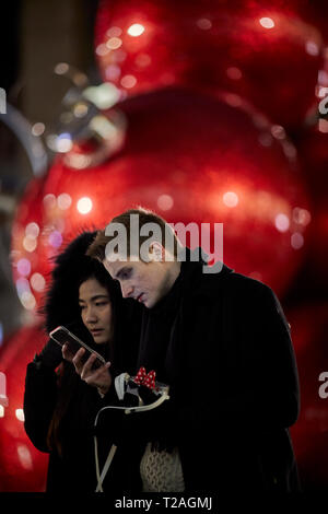 Large red oversized giant baubles Christmas Decorations  , 6th Avenue, Manhattan, New York at night Stock Photo