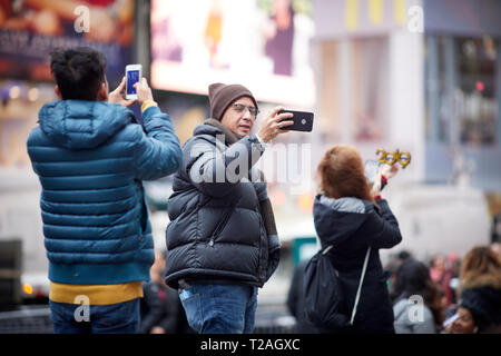 Tourists taking selfies in Times Square, New York City, New York Stock ...