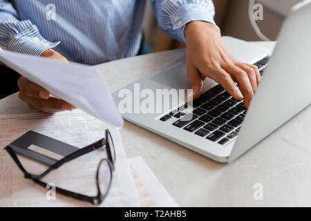 Hands of woman typing on laptop Stock Photo