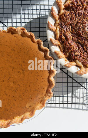 Pumpkin and pecan pies on a cooling rack Stock Photo