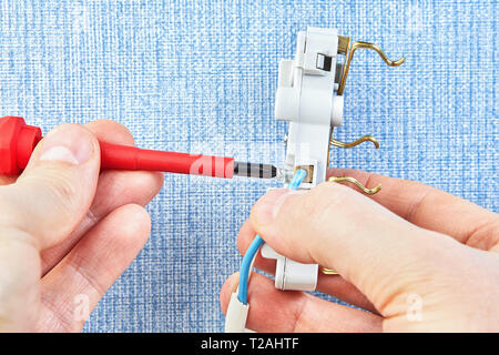 Mounting electrical wall socket by electrician with screwdriver, close-up. Stock Photo