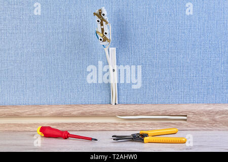 Electrical euro wall outlet with some hand tools for installing: screwdriver and wire stripper cutter. Stock Photo