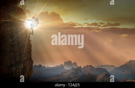 Silhouette of woman rock climbing in the Dolomites at sunrise Stock Photo