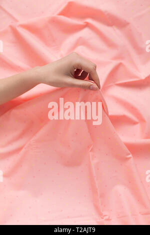 Hand of woman holding pink fabric Stock Photo