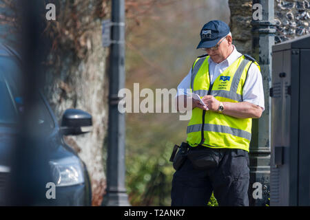 Male traffic warden from the council writing out a parking ticket in the UK. Stock Photo