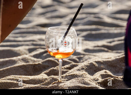 Riccione , Italy - May 1, 2018: A bottle of Martini champagne, sea beach on the background.Three refreshing summer cocktails at a beach bar. Selective Stock Photo