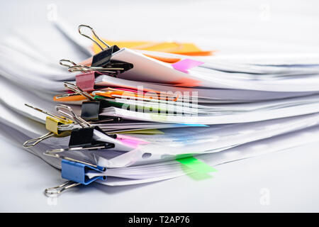 Pile various documents, reports and receipt with colorful paperclip on white background. Business and finance concepts Stock Photo