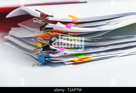 Pile various documents, reports and receipt with colorful paperclip on white background. Business and finance concepts Stock Photo
