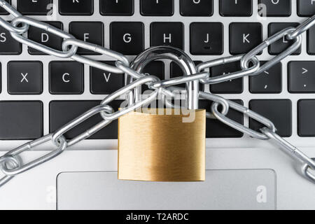 Padlock with chain on a laptop computer keyboard. Cyber security abstract concept. Stock Photo