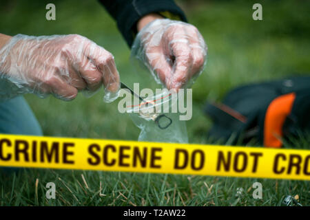 Crime scene expert collecting evidence at the murder location. Law and police concept. Selective focus Stock Photo