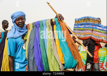 MALI Mopti, street hawker sells coloured cloth for use as shesh or Tagelmust, the turban of Touareg, Haussa and Songhai Stock Photo