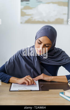 Muslim woman reading documents Stock Photo
