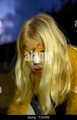 Young girl with tiger makeup mask is getting ready for Purim. model released Stock Photo