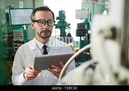 Mature Factory Worker Using Tablet Stock Photo