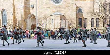 Kilt-wearing performers in the 2019 St. Patrick's Day Parade in Cleveland, Ohio march down Superior Avenue past St. John the Evangelist Cathedral. Stock Photo