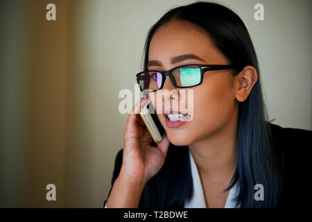 Calling businesswoman in glasses Stock Photo