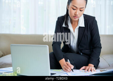 Businesswoman making corrections in documents Stock Photo