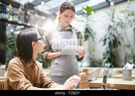 Waitress taking order from guest Stock Photo